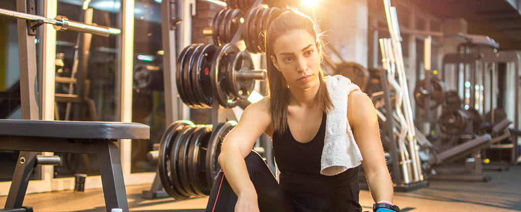 Female with smelly athletic apparel in gym after workout sweating