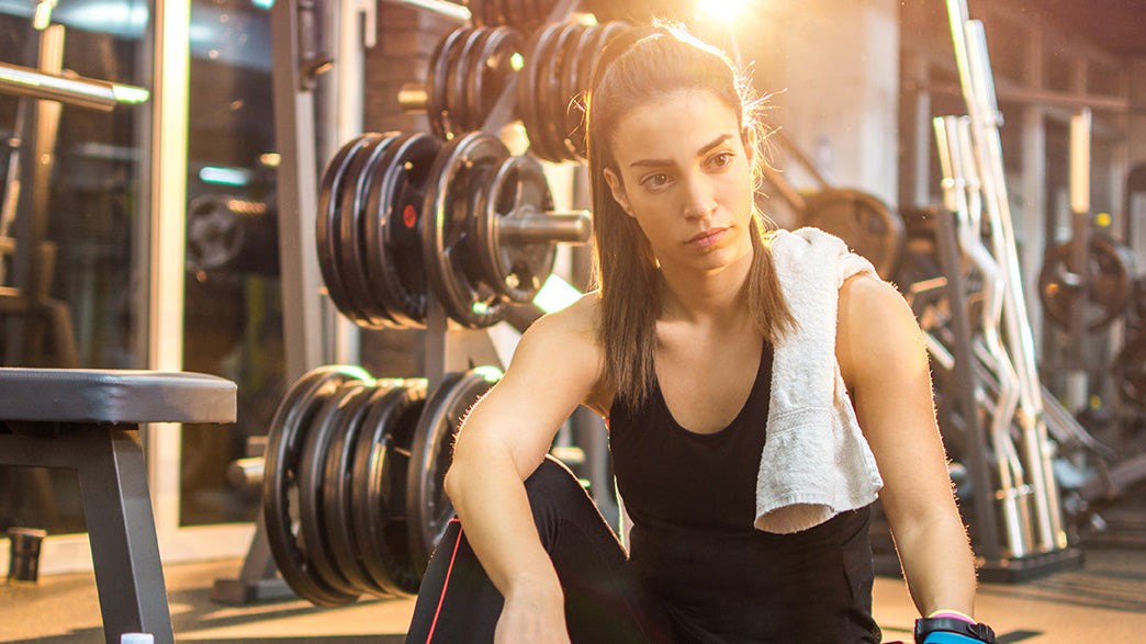 Female with smelly athletic apparel in gym after workout sweating